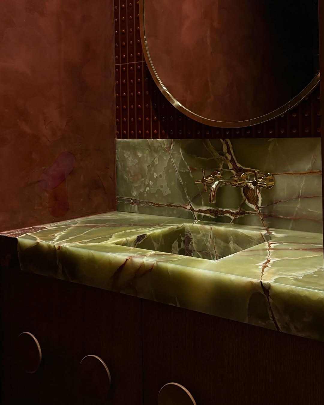 Bathroom vanity in green onyx with unlacquered brass tapware