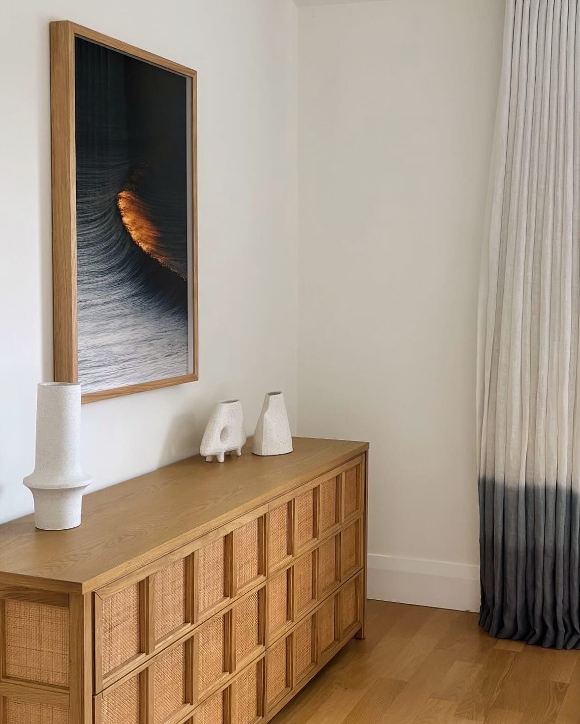 Bedroom with a white oak credenza and sculptural ceramic vessels